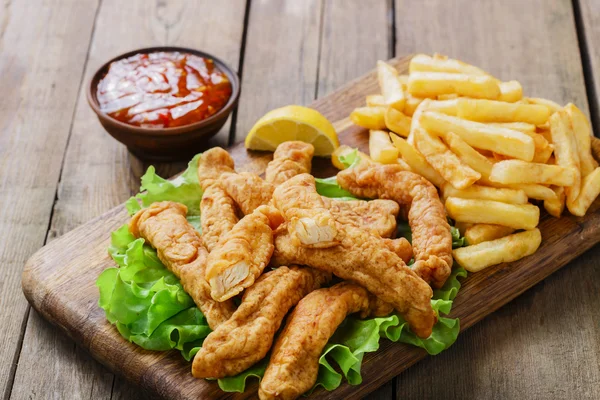 Varas de frango empanado com batatas — Fotografia de Stock