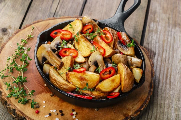 Batatas fritas com cogumelos em uma panela de ato de fritar — Fotografia de Stock