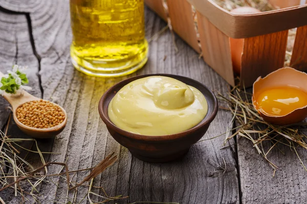 Zelfgemaakte mayonaise in een kom op een houten oppervlak — Stockfoto