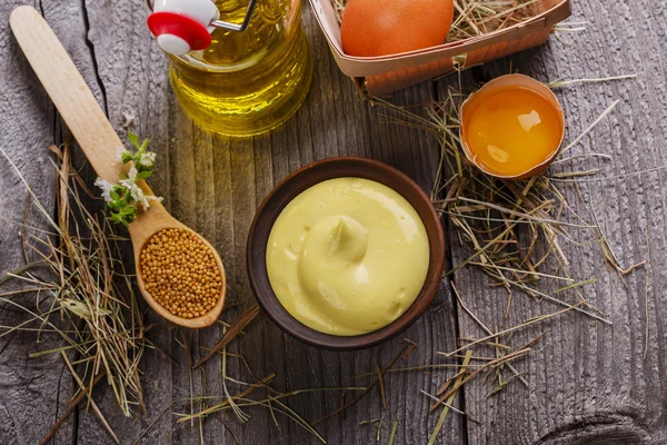 Zelfgemaakte mayonaise in een kom op een houten oppervlak — Stockfoto