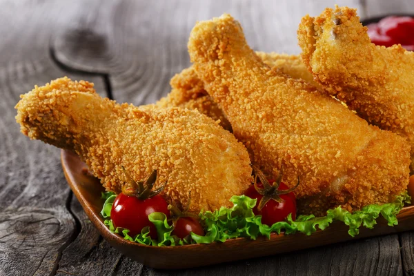 Gamba di pollo fritta in pangrattato su una superficie di legno — Foto Stock