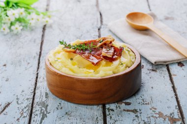 Ahşap bir kabın içinde pastırma ile patates püresi