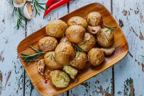 Batatas assadas inteiras em suas peles com alecrim e alho — Fotografia de Stock