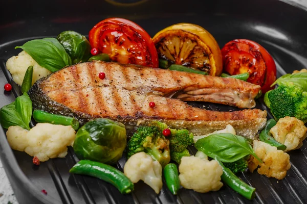 Grilled salmon with vegetables on a grill pan — Stock Photo, Image