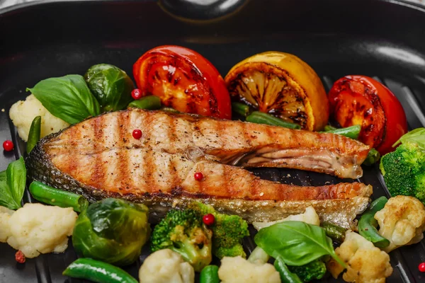 Grilled salmon with vegetables on a grill pan — Stock Photo, Image