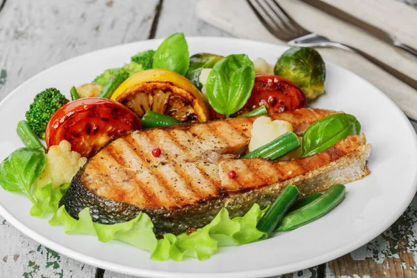 Filete de salmón a la parrilla con verduras en un plato —  Fotos de Stock