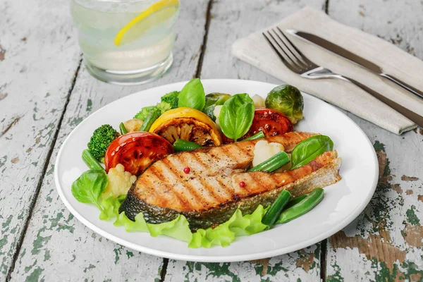 Filete de salmón a la parrilla con verduras en un plato —  Fotos de Stock