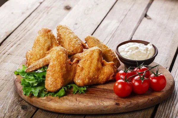 Asas de frango fritas com molho e tomate — Fotografia de Stock