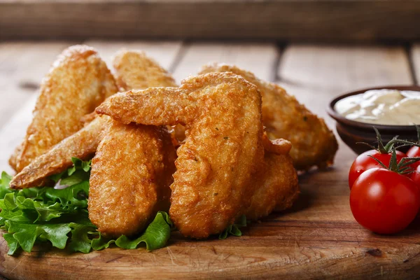 Asas de frango fritas com molho e tomate — Fotografia de Stock