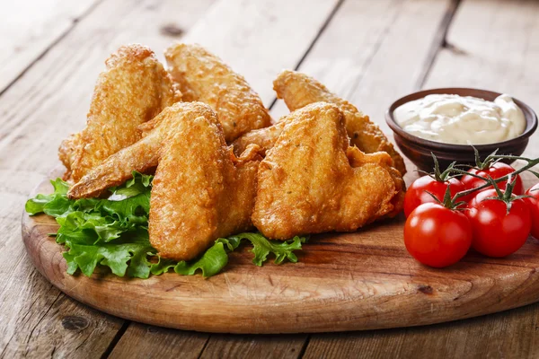 Asas de frango fritas com molho e tomate — Fotografia de Stock