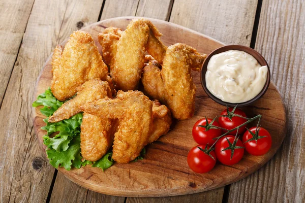 Asas de frango fritas com molho e tomate — Fotografia de Stock