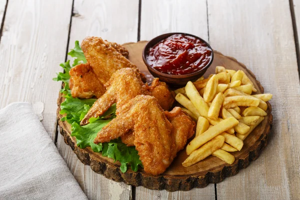 Gebakken Kippenvleugels met saus en frietjes — Stockfoto