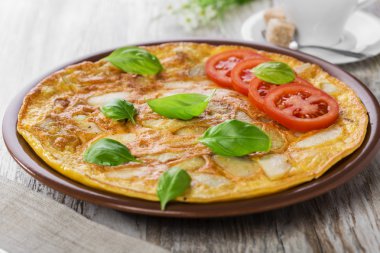 Patates omlet bir tabakta domates ile