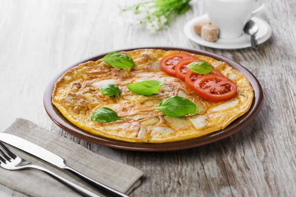 Tortilla de patatas con tomates en un plato —  Fotos de Stock