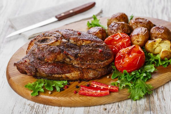 Roasted pork shoulder on the bone with potatoes
