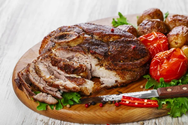 Roasted pork shoulder on the bone with potatoes — Stock Photo, Image