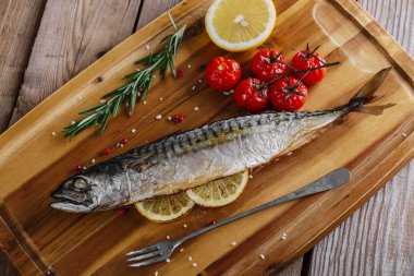 Domates ve limon ahşap tahta üzerinde ile fırında uskumru