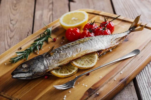 Baked mackerel with tomato and lemon on wooden board — Stock Photo, Image