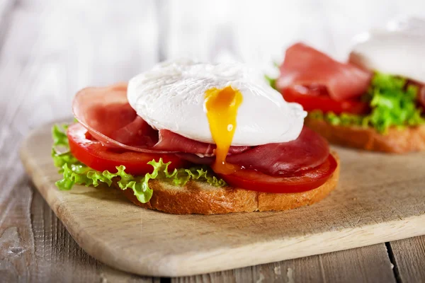Sandwich with prosciutto and poached egg tomato — Stock Photo, Image
