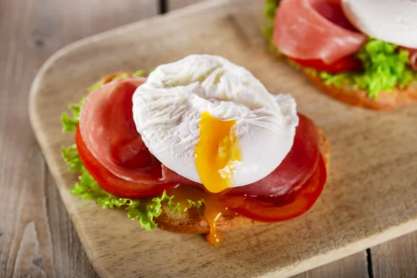 Sandwich with prosciutto and poached egg tomato — Stock Photo, Image