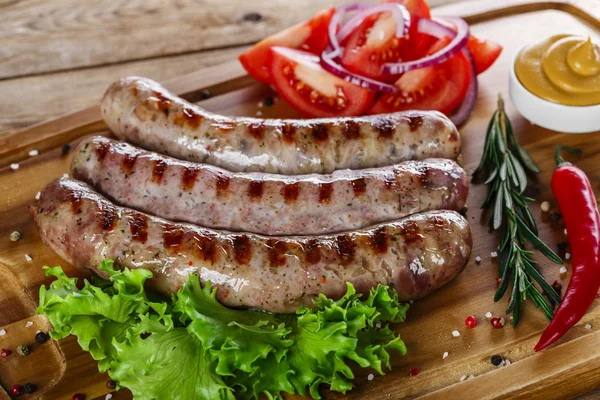 Grilled sausages on the grill on the board — Stock Photo, Image