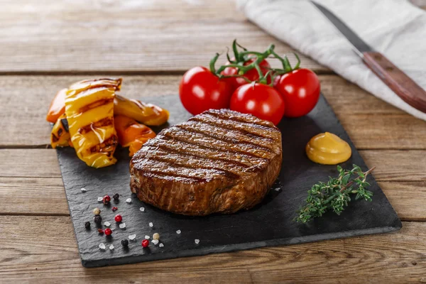 Grilovaný hovězí steak se zeleninou na dřevěný podklad — Stock fotografie