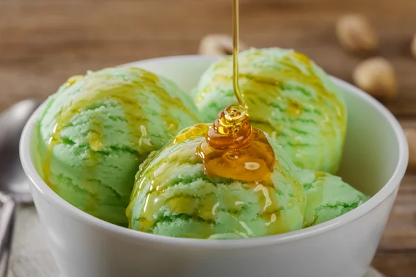 Pistachio ice cream ball poured maple syrup — Stock Photo, Image