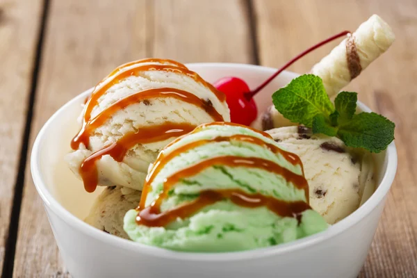 Bola de pistache e sorvete branco na tigela com caramelo — Fotografia de Stock