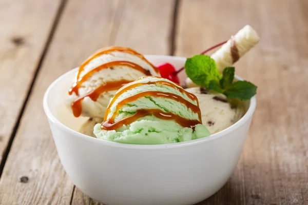 Kula pistage och vit glass i skål med karamell — Stockfoto
