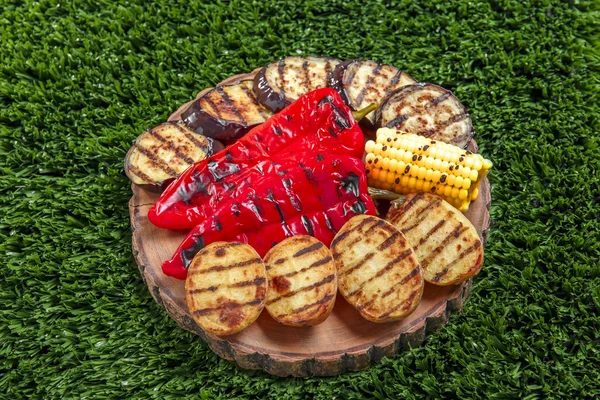 Baked grilled vegetables on the green grass — Stock Photo, Image