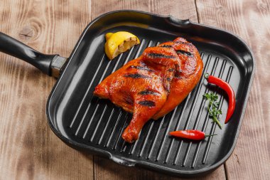 bir tavada yarım tavuk ızgara