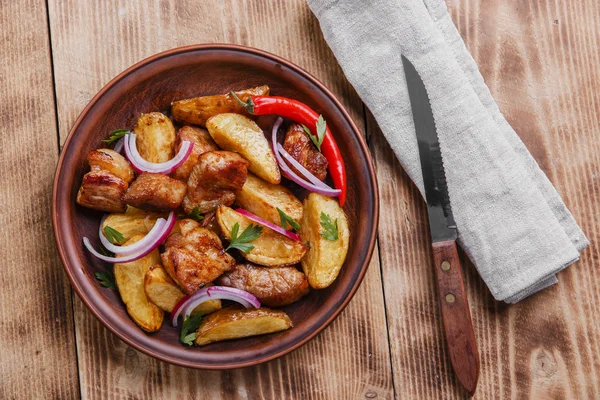 Batatas fritas assadas com placa de carne na superfície de madeira — Fotografia de Stock