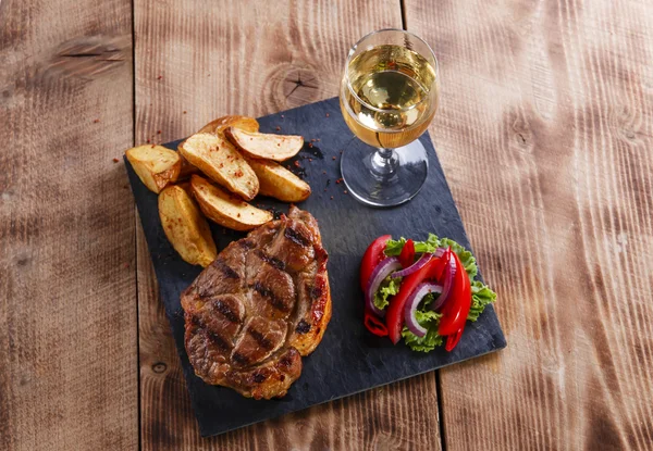 Bife de porco com batatas fritas e salada — Fotografia de Stock