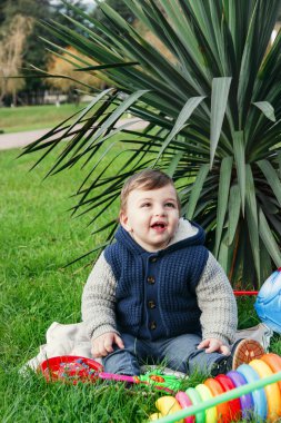 Mutlu bir yıl çocuk parkta yeşil çimenlerin üzerinde oturan