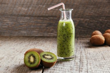bottle of kiwi juice with fresh fruits on wooden table