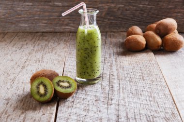bottle of kiwi juice with fresh fruits on wooden table