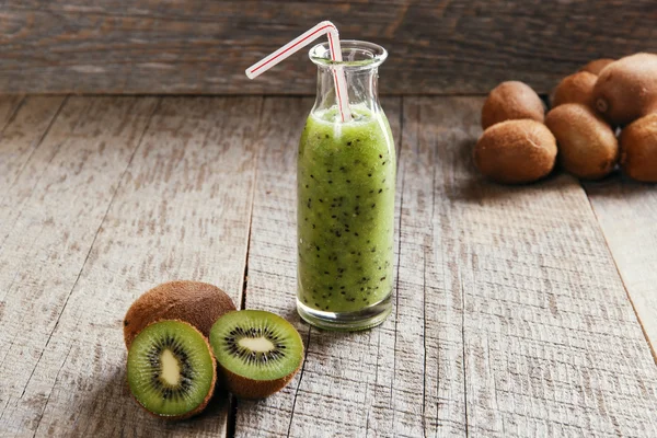 Bottle of kiwi juice with fresh fruits on wooden table — 스톡 사진
