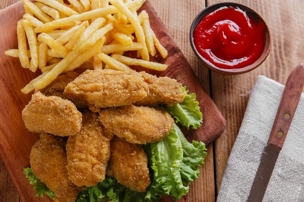 Chicken wings fried in breadcrumbs with sauce and french fries — Stock Photo, Image
