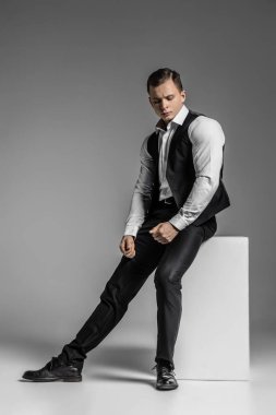 Stüdyoda güçlü ve zarif bir genç adam var.