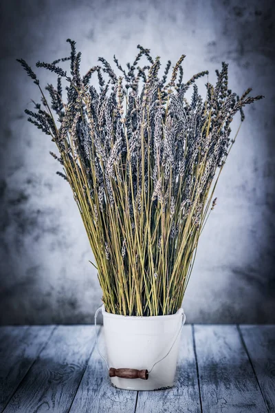 Torr lavendel i en vit hink på en trä bakgrund — Stockfoto