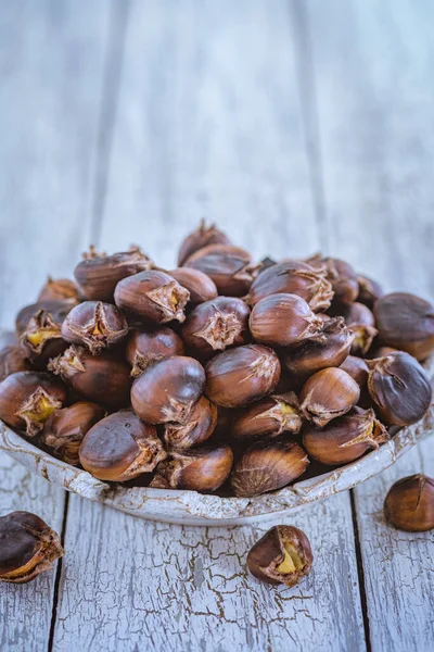 Castagne crude su fondo di legno in una ciotola di ferro. Stile rustico — Foto Stock