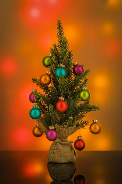 Geschmückter grüner Weihnachtsbaum auf verschwommenem, buntem Hintergrund — Stockfoto