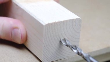 Ahşap işçiliği için bir matkap, tahta bir blokta delik açıyor.