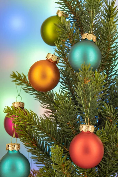 Geschmückter grüner Weihnachtsbaum auf verschwommenem, buntem Hintergrund — Stockfoto