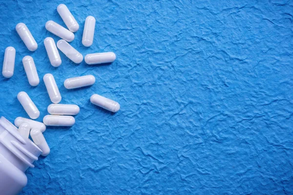 Visão Superior Pílulas Brancas Médicas Espalhadas Superfície Azul — Fotografia de Stock