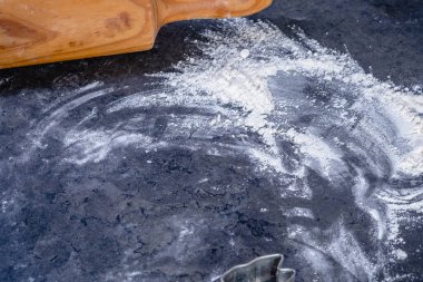 Paskalya kurabiyelerini koyu arkaplanda yapmak için merdane ve mutfak gereçleri.