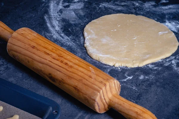 Rolling pin and kitchenware for making easter cookies on dark background