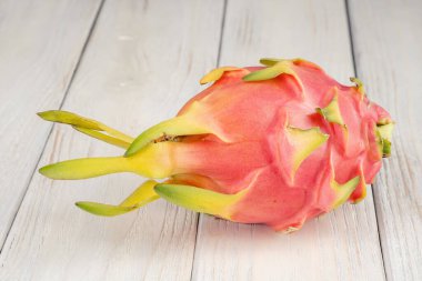Taze, pembe ejderha meyvesi, beyaz ahşap arka planda pitaya.