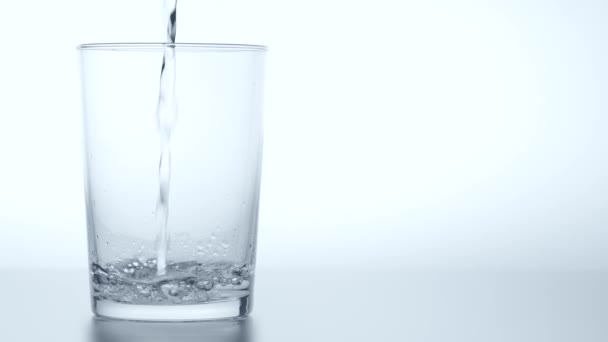 Schließen Sie das Gießen von gereinigtem Frischwasser aus der Flasche in einem Glas. — Stockvideo