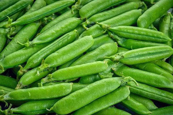 Fresh green pods or peas rotating. Peas background. Top view — Stock Photo, Image